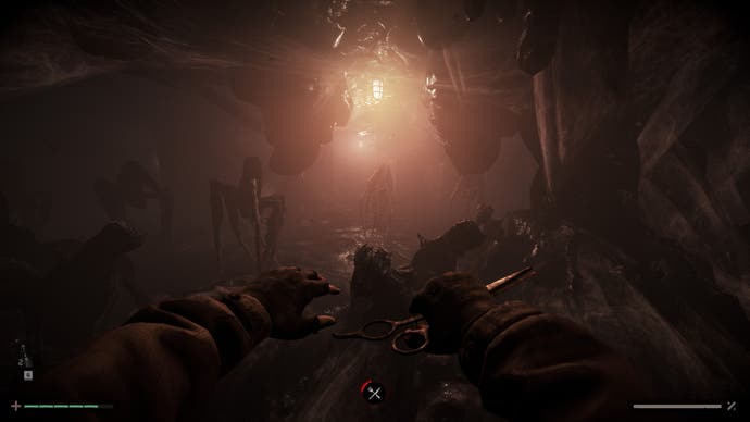 A screenshot from Total Chaos showing a dark, basement like area lit by candlelight and populated with spider-like but alien-looking creatures. In the nearground we see a characters hands and in one of them is a pair of scissors, held as if to attack with them.