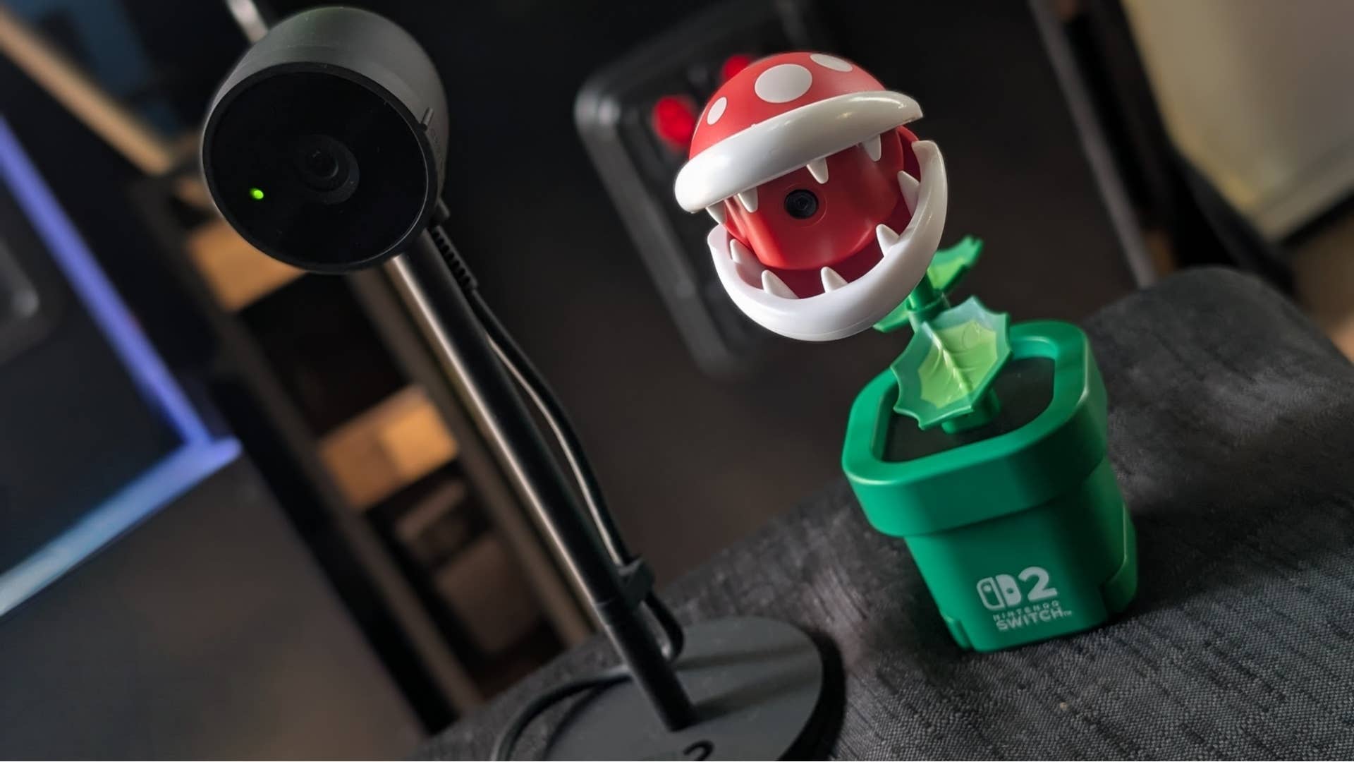 The official Nintendo Switch 2 USB camera stood next to the Hori Piranha Plant camera, which looks like a colourful plastic Piranha Plant.
